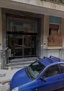 Niebieski samochód zaparkowany przed budynkiem w obiekcie LOMVARDOU-Stylish Flat next to Ampelokipi Metro St w Atenach