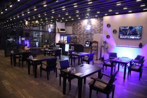a restaurant with tables and chairs and purple lighting at Sea House Hotel in Ağva
