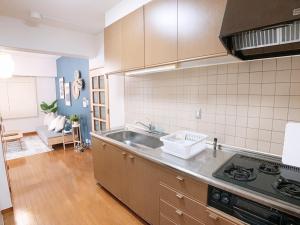 a kitchen with a sink and a stove at OUCHI HOTEL Hijiyama in Hiroshima