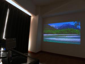 a room with a flat screen tv on a wall at OUCHI HOTEL Hijiyama in Hiroshima