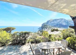 uma mesa e cadeiras com vista para o oceano em La Casetta delle Api em Capri