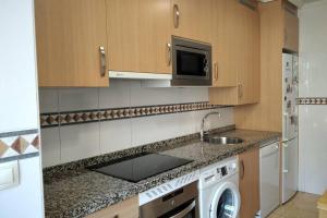 a kitchen with a sink and a washing machine at LA TERRAZA DE LA FLORIDA terraza 225 m2 in Oviedo