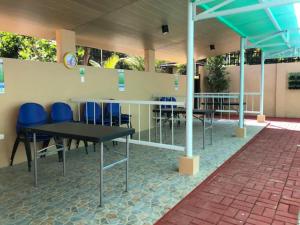 a group of tables and blue chairs in a building at Felicitas Tagaytay in Tagaytay