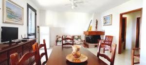a living room with a dining room table and a television at La Dolce Vista in Magomadas