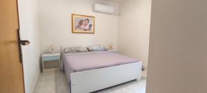 a small bedroom with a bed and a picture on the wall at La Dolce Vista in Magomadas