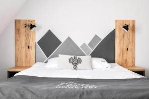 a bedroom with a large bed with a white bedspread at Nowe Izby in Szaflary