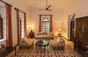 un soggiorno con divano, sedie e finestra di Marbella Guest House a Sinquerim
