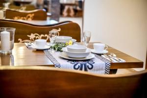 een houten tafel met een tafelkleed met borden en glazen bij Czarna Turnia Villa w Zakopanem in Zakopane