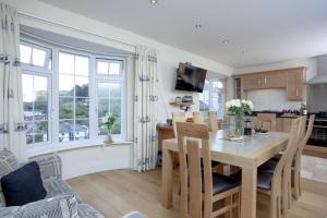 Una cocina y un comedor con mesa y sillas. en Waterview House, Kingswear, en Kingswear
