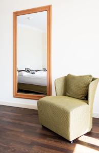 a chair and mirror in a room with a bedroom at Hotel Seeburg in Lucerne
