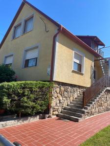 a house with a stone staircase in front of it at György Vendégház in Magyarpolány