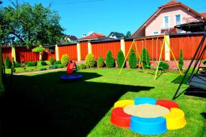 une cour avec quatre frisbees colorés sur l'herbe dans l'établissement Vila Deluxe & Apartmány Riviéra Liptov Bešeňová, à Bešeňová