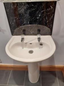 a white sink in a bathroom with a mirror at Vergam Terrace in Fishguard