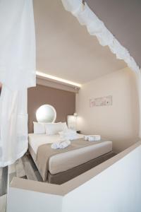 a white bedroom with a bed with white curtains at Villa Nickolas in Paleo Tsifliki