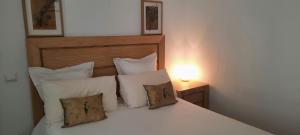 1 dormitorio con 1 cama blanca con almohadas y lámpara en Apartamento en Reina Victoria en Santander