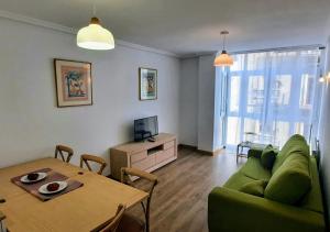 sala de estar con sofá verde y mesa en Apartamento en Reina Victoria en Santander