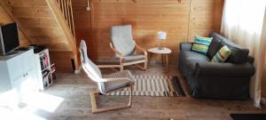 a living room with a couch and two chairs at morska chata in Lubiatowo