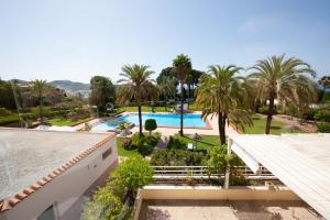 Cette chambre offre une vue sur un complexe doté d'une piscine et de palmiers. dans l'établissement Las Palmeras Beach with Community Pool, à La Herradura