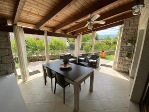 una sala da pranzo con tavolo, sedie e ventilatore a soffitto di Villa Ibiscus Cala Sinzias a Castiadas