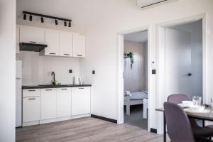 a kitchen with white cabinets and a table and a dining room at Silva in Rewal