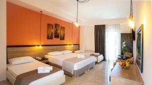 a hotel room with two beds and a table at Villa Nickolas in Paleo Tsifliki