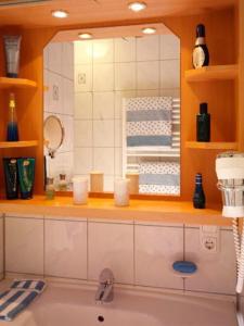 un bagno con un lavandino e uno specchio sopra una vasca di App.-Haus zur Europa-Therme a Bad Füssing