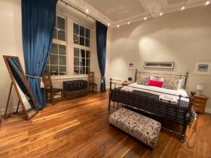 1 dormitorio con 1 cama con cortinas azules y suelo de madera en Royal Mile Mansions by Edinburgh City Apartments, en Edimburgo