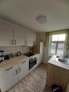 a kitchen with white cabinets and a stove top oven at Ferienwohnung Ballstrasse 28 in Quedlinburg