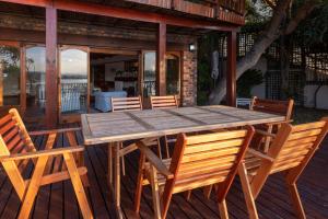 a wooden table and chairs on a deck at Paquita Self Catering Holiday House in Knysna