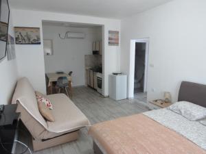 a bedroom with a bed and a living room at Apartments Jovanović in Perast