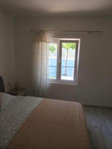 a bedroom with a bed and a window at Apartments Jovanović in Perast