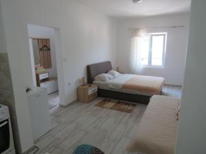 a small bedroom with a bed and a window at Apartments Jovanović in Perast