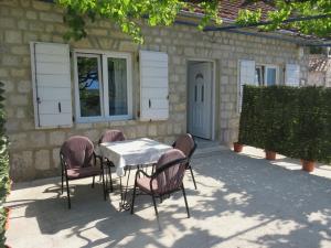 a table and chairs in front of a building at Apartments Jovanović in Perast