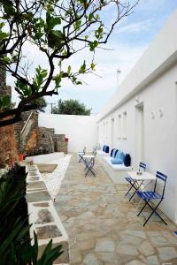 a patio with blue chairs and tables and a building at Beba's Studios in Batsi