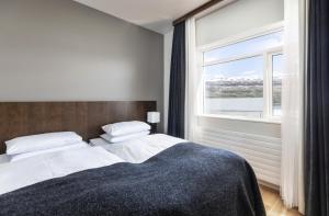 1 dormitorio con 1 cama grande y ventana grande en Hotel Kea by Keahotels, en Akureyri