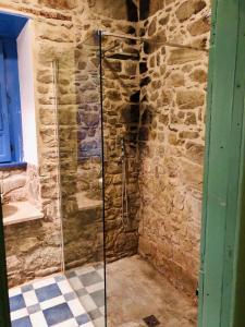 a bathroom with a shower in a stone wall at Casa della Lampara in Capo dʼOrlando +33 photos
