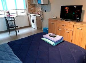 Pokój z łóżkiem i telewizorem oraz kuchnią w obiekcie Estudio Playa del Cura w mieście Torrevieja