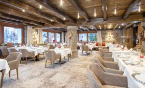 a restaurant with white tables and chairs and windows at Parkhotel Seefeld in Seefeld in Tirol