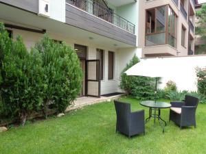 a patio with a table and chairs in a yard at Къща за гости А. Б. В. in Nesebar