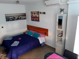 sypialnia z łóżkiem z fioletową pościelą i niebieskimi poduszkami w obiekcie Estudio Playa del Cura w mieście Torrevieja
