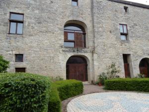 ein Steingebäude mit einer großen Tür vor der Tür in der Unterkunft La Maison Royale in Pesmes