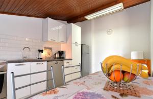 a kitchen with a table with a bowl of fruit on it at Aparments David 1376 in Štinjan