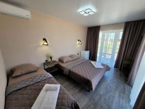 a hotel room with two beds and a window at VIP HOTEL ZATOKA in Zatoka +158 photos