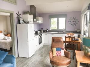 a kitchen with a refrigerator and a chair and a table at Abergafren Lodge in Porthmadog