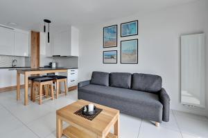 a living room with a couch and a table at Downtown Apartments Seaside Gdańsk Letnica in Gdańsk