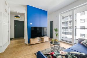 een woonkamer met een blauwe muur en een tv bij Manufaktura Centrum in Łódź