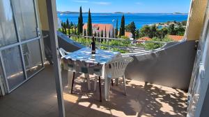 Una mesa y sillas en un balcón con vista al mar. en Apartments Kust, en Mlini