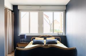 - une chambre avec un grand lit et 2 fenêtres dans l'établissement L'austerlitz, T2 au coeur de Strasbourg, à Strasbourg