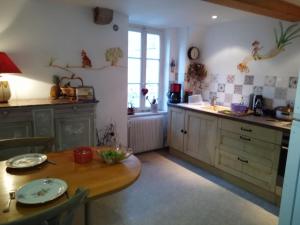 a kitchen with a wooden table and a dining room at Le Baudinot in Sélestat