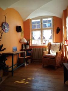 a room with a chair and a table and windows at Le Baudinot in Sélestat